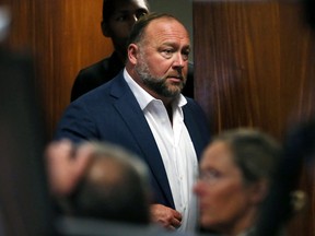 Alex Jones walks into the courtroom in front of Scarlett Lewis and Neil Heslin, parents of 6-year-old Sand Hook shooting victim Jesse Lewis, at the Travis County Courthouse in Austin, Texas, July 28, 2022.