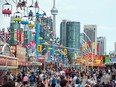 People make their way through the midway during opening day of the Canadian National Exhibition in Toronto on August 19, 2022.