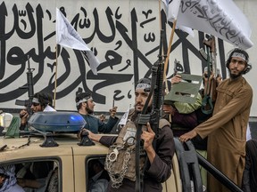 Taliban fighters hold their weapons as they celebrate one year since they seized the Afghan capital, Kabul, in front of the U.S. Embassy in Kabul, Afghanistan, Monday, Aug. 15, 2022. (AP Photo/Ebrahim Noroozi)