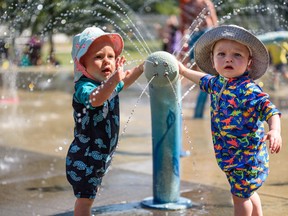 Children cool down during Alberta’s heat wave at the spray park at West Confederation Park in Calgary.  Azin Ghaffari/Postmedia