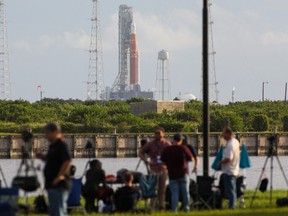News media members react as NASA's next-generation moon rocket, the Space Launch System (SLS) , with its Orion crew capsule on top, sits on the pad after the launch of the Artemis I mission was scrubbed, at Cape Canaveral, Florida, U.S., August 29, 2022.