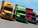 FILE - Yellow, green and red semi-trailer trucks stand side-by-side at a rest area in North America. PHOTO BY GBLAKELEY / ISTOCK / GETTY IMAGES PLUS