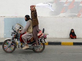 Taliban supporters in Kabul drive past a crying girl as they celebrate the first anniversary of the city's fall, and the crackdown on women's rights, August 15, 2022.