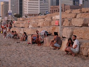 Beachgoers take cover in the Israeli coastal city of Tel Aviv after rockets were launched from the Gaza Strip on Aug. 7, 2022.
