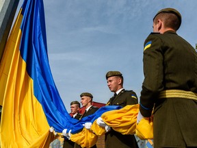 Ukrainian members of the honor guard attend a ceremony marking the National Flag Day of Ukraine, in the western city of Lviv, on August 23, 2022. (Photo by YURIY DYACHYSHYN / AFP)