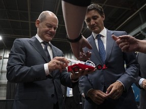 Canadian Prime Minister Justin Trudeau and German Chancellor Olaf Scholz examine a hydrogen powered toy car as they tour a trade show, Tuesday, August 23, 2022 in Stephenville, Newfoundland and Labrador.