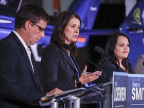 Danielle Smith, centre, makes a comment as Todd Loewen, left, and Rajan Sawhney listen during the United Conservative Party of Alberta leadership candidate's debate in Medicine Hat, Alta., Wednesday, July 27, 2022.