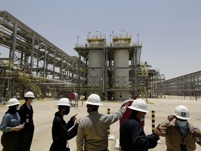 FILE - Saudi Aramco engineers and journalists look at the Hawiyah Natural Gas Liquids Recovery Plant in Hawiyah, in the Eastern Province of Saudi Arabia on June 28, 2021. Saudi oil company Aramco's half-year profits peaked just shy of $88 billion for the first half of the year as oil prices remain high globally. The oil and gas company, which is nearly entirely state-owned, said Sunday, Aug. 14, 2022, it also saw a 90% surge in net profits for the second quarter of 2022 compared to the same time last year.