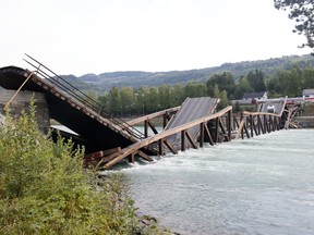 A view of a bridge that has collapsed over the River Laagen, in Gudbrandsdalen, Norway, Monday, Aug. 15, 2022. A wooden bridge over a river in southern Norway has collapsed with a car plunging into the water and a truck getting stuck on a collapsed section. Police said the drivers of both vehicles were rescued and doing well.