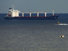 A boat with Russian, Ukrainian, Turkish and U.N. officials heads to the Sierra Leone-flagged cargo ship Razoni, to check if the grain shipment is in accordance with a crucial agreement signed last month by Moscow and Kyiv, at an inspection area in the Black Sea off the coast of Istanbul, Turkey, Wednesday, Aug. 3, 2022. The cargo ship Razoni, loaded up with 26,000 tons of corn, set sail from Ukraine's Odesa on Monday, enroute to final destination, Lebanon.