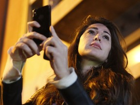 FILE - Lebanese Journalist Dima Sadek uses her cellphone to make a video of an anti-government protest, in Beirut, Lebanon, Dec. 4, 2019. The stabbing of author Salman Rushdie on Friday, Aug. 12, 20222 in western New York, has laid bear to divisions within Lebanon's Shiite community of which some have expressed support for the act while others harshly criticized it leading to death threats against Sadek, a prominent journalist. The assailant, 24-year-old Hadi Matar, is a dual Lebanese-U.S. citizen, and his father lives in a village in Hezbollah-dominated southern Lebanon.