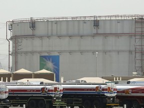 FILE - Fuel trucks line up in front of storage tanks at the North Jiddah bulk plant, an Aramco oil facility, in Jiddah, Saudi Arabia, March 21, 2021. Saudi Aramco announced a $2.65 billion agreement on Monday, Aug. 1, 2022, to acquire Valvoline's global products business, which includes motor oils, transmission fluids, coolants and other automotive maintenance products. Valvoline said the transaction will separate its global products from its retail services businesses, transforming it into a purely automotive service provider.