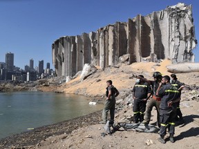 FILE - A rescue team surveys the site of a massive explosion in the port of Beirut, Lebanon, Aug. 7, 2020. A group of Lebanese and international organizations on Wednesday, Aug, 3, 2022, called on members of the U.N. Human Rights Council to send a fact-finding mission to investigate the Beirut Port blast two years ago. The call came as the domestic investigation has been stalled since December following legal challenges by charged officials against the judge leading the investigation into the Aug. 4, 2020 blast that killed nearly 220 and injured over 6,000.