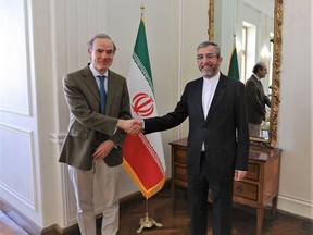 FILE - In this photo released by the Iranian Foreign Ministry, Enrique Mora, a leading European Union diplomat, left, shakes hands with Iran's top nuclear negotiator Ali Bagheri Kani in Tehran, Iran, March 27, 2022. Iran and the European Union said Wednesday, Aug. 3, 2022, that they would send representatives to Vienna amid what appears to be a last-ditch effort at reviving talks over Tehran's tattered 2015 nuclear deal with world powers. Mora who chairs the talks, wrote on Twitter that the negotiations would focus on the most recent draft on restoring the agreement, while Tehran said it was dispatching Kani to the Austrian capital. (Iranian Foreign Ministry via AP, File)