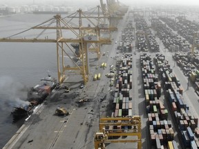 FILE - This Photo made available from a Government of Dubai Media Office's footage, shows the smoke from a container ship, Ocean Trader after an explosion, July 8, 2021. A Dubai court has found that the cargo ship's mishandled peroxide caused the explosion, Abu Dhabi's English-language newspaper, a state-linked newspaper reported Thursday, Aug. 18, 2022. The Dubai Misdemeanor Court sentenced five crew members on board the vessel to one-month suspended prison sentences and fined them 100,000 dirhams ($27,225) for not caring for the cargo and allowing fumes to build up, according to the newspaper.