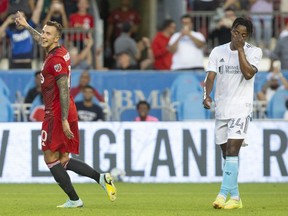 Toronto FC's Federico Bernardeschi (left) celebrates after converting a penalty shot as New England Revolution's DeJuan Jones reacts during first half MLS action in Toronto on Wednesday August 17, 2022.