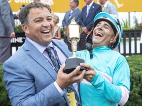 Jockey Rafael Hernandez, right, celebrates with trainer Kevin Attard in the winners circle after riding Moira over the finish line to win the 163rd running of the $1-million Queen's Plate in Toronto on Sunday, August 21, 2022.