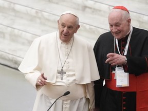 Pope Francis, left, and Cardinal Marc Ouellet arrive at the opening of a 3-day Symposium on Vocations in the Paul VI hall at the Vatican on Feb. 17, 2022. Pope Francis says there is insufficient evidence to open a canonical investigation for sexual assault against Ouellet.