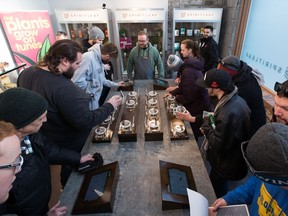 Pot shop owner SNDL Inc. says it will acquire cannabis manufacturer The Valens Company Inc. and combine the businesses. People look at cannabis on display inside Spiritleaf on Monday, April 1, 2019.
