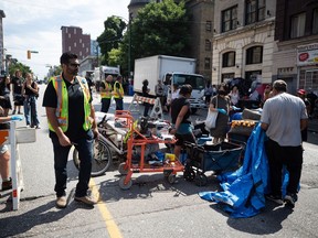 A person's belongings are placed on the street to be moved to storage after his tent was cleared from the sidewalk at a sprawling homeless encampment on East Hastings Street in the Downtown Eastside of Vancouver, on Tuesday, August 9, 2022. Police say a charge of assault with a weapon has been laid against a woman after officers in Vancouver were allegedly attacked in the same area as a tent encampment was being removed from the city's Downtown Eastside.