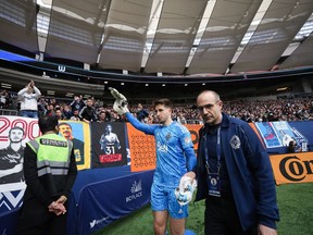 Vancouver Whitecaps goalkeeper Thomas Hasal leaves the field with an injury as Dr. Dory Boyer supports his hand with a towel during the second half of an MLS soccer game against Toronto FC in Vancouver, B.C., Sunday, May 8, 2022.