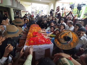 Family members stretch their arms out to touch the coffin containing the remains of Chandra Shekhar, an Indian army soldier who went missing 38 years ago, in Haldwani, India, Wednesday, Aug. 17, 2022. The soldier and 17 other colleagues were occupying a ridge on Siachen Glacier, high in the Karakoram range in disputed Kashmir's Ladakh region, in May 1984 when they were hit by an avalanche, officials said. (AP Photo)
