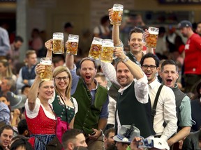 FILE - In this Saturday, Sept. 21, 2019 file photo, visitors lift glasses of beer during the opening of the 186th 'Oktoberfest' beer festival in Munich, Germany. The annual Oktoberfest festival is finally on again for this fall, following a two-year hiatus due to the coronavirus pandemic. The head of the famous Bavarian beer festival in Munich said Thursday the celebrations will be held without any pandemic restrictions from Sept. 17 to Oct. 3, 2022.