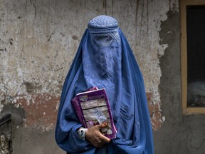 Arefeh 40-year-old, an Afghan woman leaves an underground school, in Kabul, Afghanistan, Saturday, July 30, 2022. She attends this underground school with her daughter who is not allowed to go to public school. For most teenage girls in Afghanistan, it's been a year since they set foot in a classroom. With no sign the ruling Taliban will allow them back to school, some girls and parents are trying to find ways to keep education from stalling for a generation of young women.