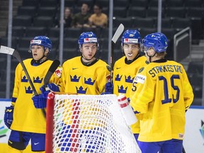 Sweden's Fabian Lysell (11), Isak Rosen (23), Liam Ohgren (25) and Ake Stakkestad (15) celebrate a goal against Austria during second period IIHF World Junior Hockey Championship action in Edmonton on Friday August 12, 2022.