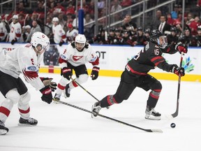 Canada's Connor Bedard (16) gets the shot away as Switzerland's Giancarlo Chanton (5) and Noah Delemont (9) give chase during second period IIHF World Junior Hockey Championship quarterfinal action in Edmonton on Wednesday August 17, 2022.