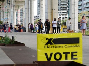 People line up outside a polling station to vote during  a federal election, in Toronto, September 20, 2021.