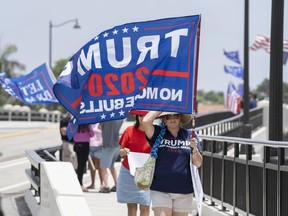 Trump supporters carry flags near Mar-a-Lago in Palm Beach, Fla., on Tuesday, August 9, 2022.