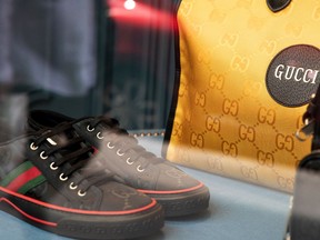 A pair of luxury sneakers and leather luggage sit on display at Gucci store.