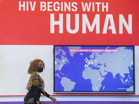 A woman walks by a sign during the AIDS 2022 conference in Montreal, Sunday, July 31, 2022.