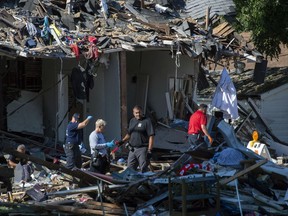 Emergency personnel search the debris, Thursday, Aug. 11, 2022, in Evansville, Ind., as authorities work to determine the cause of a house explosion that killed three people and left another person hospitalized. The explosion the day before damaged 39 homes.