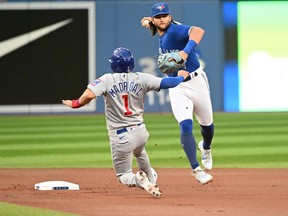 Toronto Blue Jays shortstop Bo Bichette, right, throws to first base to complete a double play on Chicago Cubs' Willson Contreras after forcing out Nick Madrigal (1) at second base in first inning interleague baseball action in Toronto on Tuesday, August 30, 2022.
