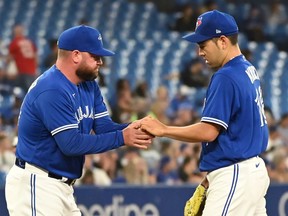 Toronto Blue Jays starting pitcher Yusei Kikuchi, left, is taken out of the game by manager John Schneider in the fourth inning American League baseball action against the Baltimore Orioles in Toronto on Monday, August 15, 2022.