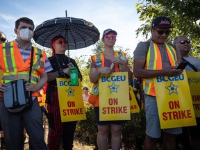 Members of the British Columbia General Employees' Union picket outside a B.C. Liquor Distribution Branch facility, in Delta, B.C., on August 15, 2022. A union representing thousands of provincial government workers in B.C. has escalated job action with a ban on overtime.