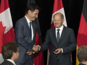 Prime Minister Justin Trudeau and German Chancellor Olaf Scholz shake hands at the start of a signing ceremony after signing a deal to kick-start a transatlantic hydrogen supply chain, on Tuesday, August 23, 2022 in Stephenville, Newfoundland and Labrador. The head of an advocacy group pushing to decarbonize Canada's public transit systems says experience with public transit in Canada is any indication, getting the projects off the ground may be more difficult than expected.