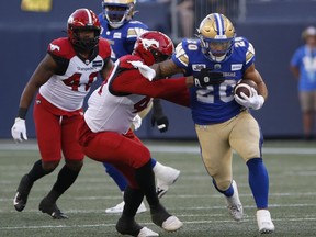 Winnipeg Blue Bombers' Brady Oliveira (20) runs for the first down against Calgary Stampeders during the first half CFL action in Winnipeg Thursday, August 25, 2022.