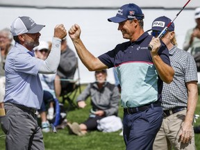 Padraig Harrington, right, celebrates his first round win with Doug Barron during the PGA Tour Champion's Shaw Charity Classic golf event in Calgary, Alta., Friday, Aug. 5, 2022.THE CANADIAN PRESS/Jeff McIntosh