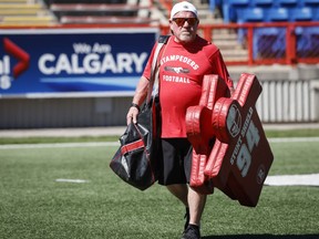 Calgary Stampeders' trainer George Hopkins, who is in his 51st year with the CFL team carries equipment in Calgary, Monday, July 11, 2022.THE CANADIAN PRESS/Jeff McIntosh