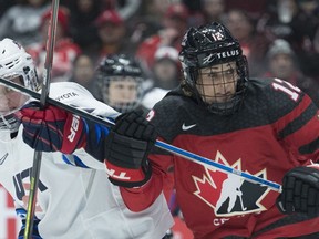 Team Canada's Meaghan Mikkelson fights for control of the puck with U.S.A.'s Hayley Scamurra during third period of Women's Rivalry Series hockey action in Vancouver, Wednesday, February 5, 2020.THE CANADIAN PRESS/Jonathan Hayward