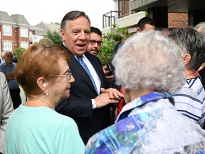 Coalition Avenir Québec Leader François Legault speaks with people during a campaign stop at a seniors residence, Tuesday, Aug. 30, 2022, in St-Georges, Que. Quebecers are going to the polls for a general election on Oct. 3.