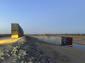 This photo provided of Univision Arizona shows empty shipping containers toppled over Sunday overnight on the Mexico-US international borderline in Yuma, Ariz., on Monday, Aug. 16, 2022. An effort by Arizona's Republican Gov. Doug Ducey to use shipping containers to close a 1,000-foot gap in the U.S.-Mexico border wall suffered a temporary setback over the weekend when two containers stacked on top of each were somehow toppled over. The stacked pair of containers were righted by early Monday morning.