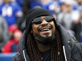 FILE - Marshawn Lynch stands on the field before an NFL football game between the Buffalo Bills and the Indianapolis Colts in Orchard Park, N.Y., Nov. 21, 2021. Police in Las Vegas say the former NFL running back was asleep and smelled of alcohol when he was found in his damaged sports car this week and arrested on suspicion of driving while intoxicated. Lynch's attorneys responded Thursday, Aug. 11, 2022, with a statement saying Lynch was in a parked car, not driving, and a DUI charge won't stick.