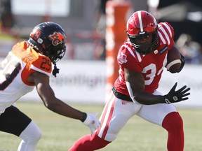 Calgary Stampeders running back Dedrick Mills, right, gets away from BC Lions defensive back Jalon Edwards-Cooper during first half CFL football action in Calgary, Saturday Aug. 13, 2022.