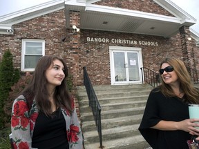 Former Bangor Christian Schools sophomore Olivia Carson, then 15, of Glenburn, Maine, left, stands with her mother Amy while getting dropped off on the first day of school on August 28, 2018 in Bangor, Maine. Parents of students enrolled in religious schools fought for years -- all the way to the Supreme Court -- for tuition to be reimbursed by the state, the same as other private schools. But only one religious school has signed up to participate so far.