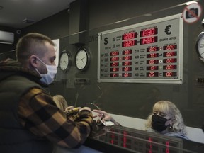 FILE - A man changes Turkish lira for USD and Euro at a currency exchange shop, in Ankara, Turkey, Tuesday, Nov. 23, 2021. Annual inflation in Turkey soared to nearly 80% in July. The Turkish Statistical Institute said Wednesday Aug. 3, 2022 that consumer prices rose by 79.6% from a year earlier, up about 1 percentage point from June data.