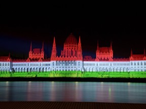 The colors of the Hungarian flag illuminate the Parliament building to mark the national holiday celebrating Hungary's statehood in Budapest, Hungary, Saturday, Aug. 20, 2022. State founder St. Stephen I, the first king of Hungary was crowned in 1000 A.D.